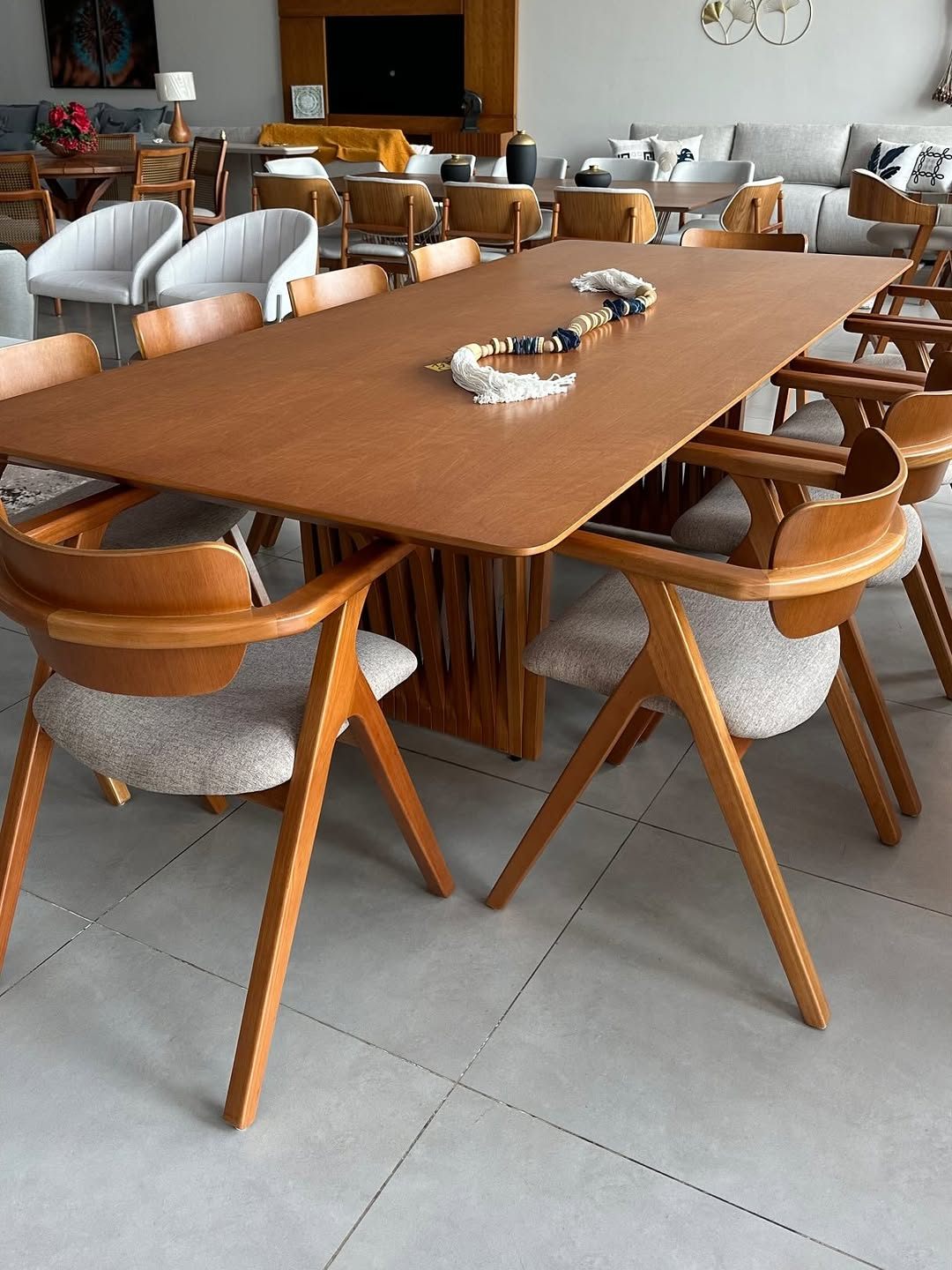 Showroom da MC Móveis Interiores com mesa de jantar retangular em madeira e cadeiras estofadas